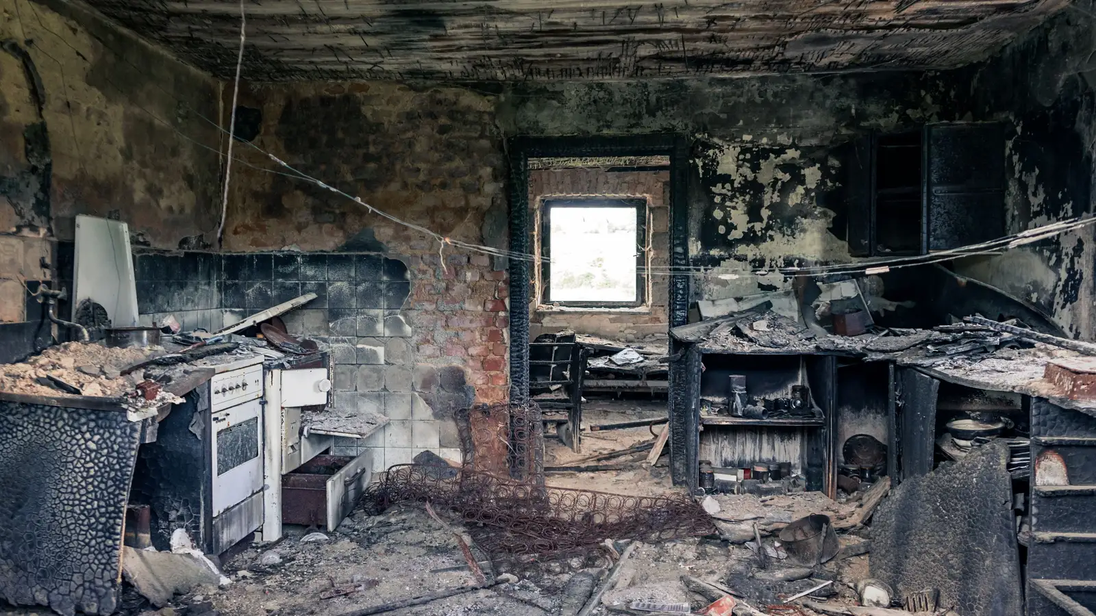 The charred, soot-covered interior of a fire-damaged home